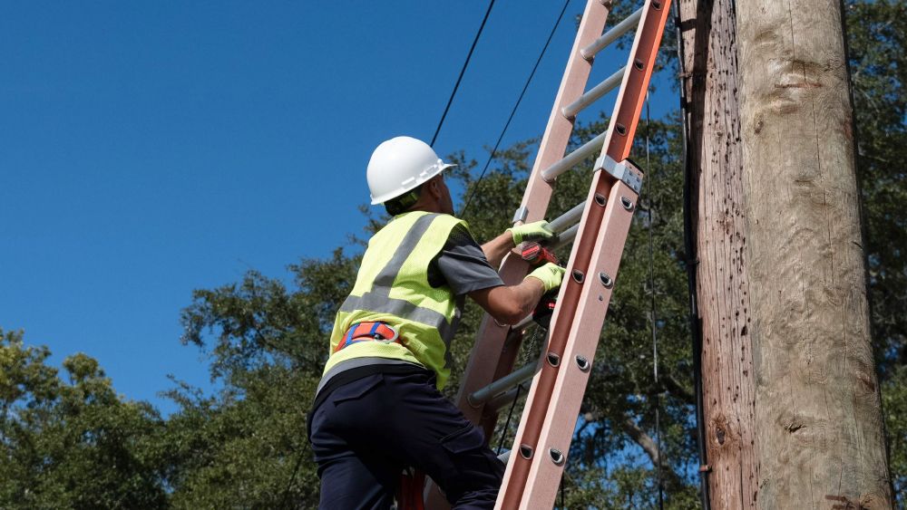 Cable Technician Climbing a Ladder